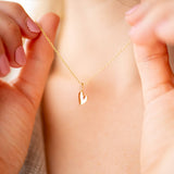 Close-up of a person wearing a Pure Heart Necklace with a gold heart charm.
