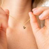 Pure Heart Necklace worn by a model, showcasing a delicate gold heart pendant on a fine chain.
