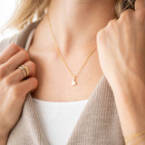 Model wearing a gold Pure Heart Necklace, showcasing its delicate heart pendant on a stylish outfit.