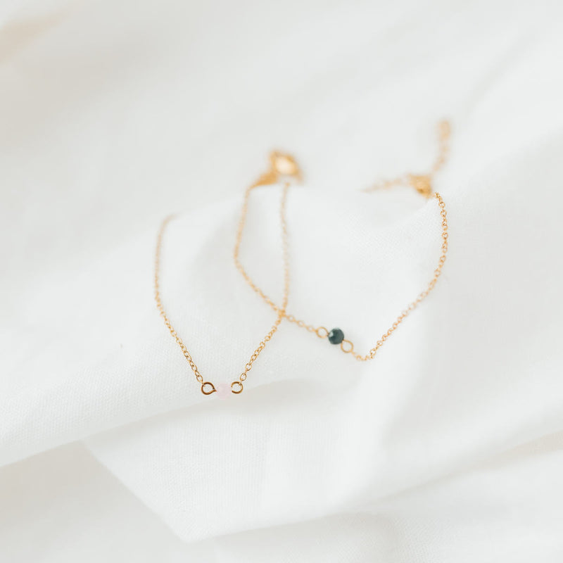 Malin Bracelet: zartes Goldarmband mit dunkelgrünen und rosa Glassteinen