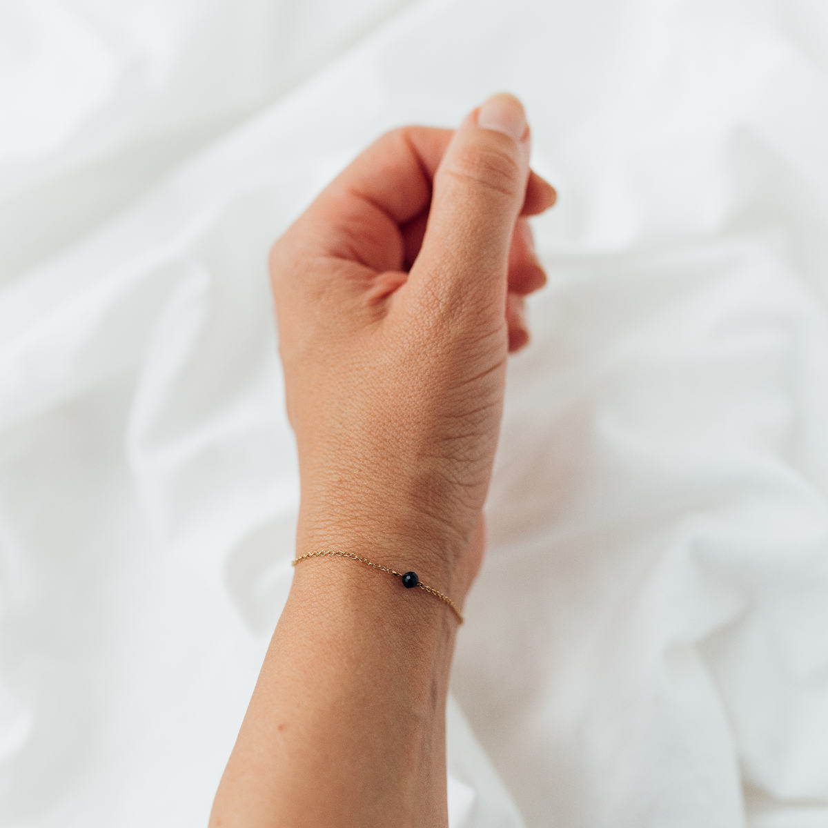 Malin Bracelet: zartes Goldarmband mit dunkelgrünem Glasstein, Tragebild